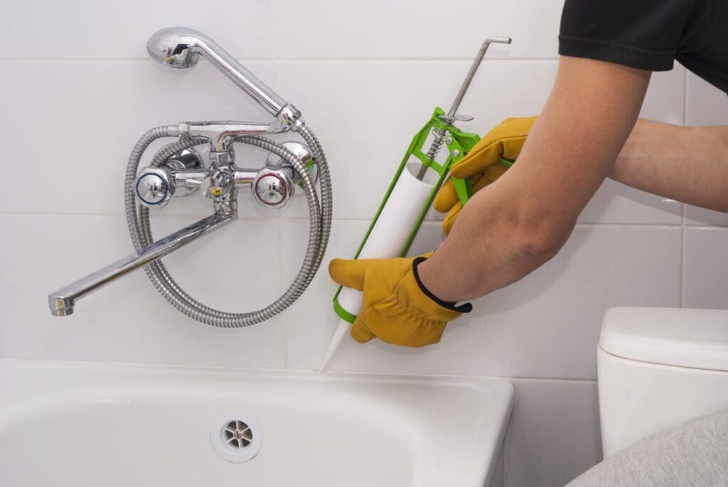 silicone sealant plumber apply silicone sealant to the joint bathtubs and ceramic tile